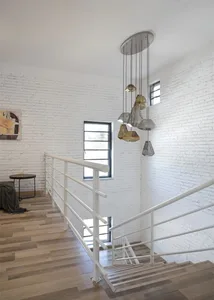 Modern interior staircase featuring brass lamps, white brick walls, and hardwood flooring.