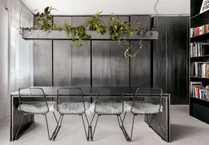 Industrial dining room featuring metal furniture with white cushions and a wall-mounted metal shelf with hanging plants.