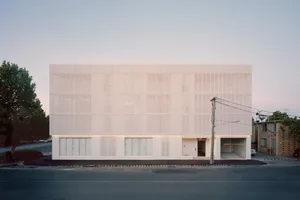 Modern office building with concrete exterior and large windows.