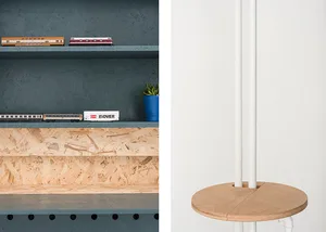 A minimalist interior design featuring a wood shelf with a blue plant pot and model trains.