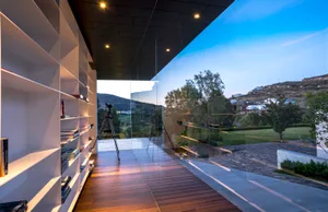 A modern library with a glass wall overlooking a scenic landscape.
