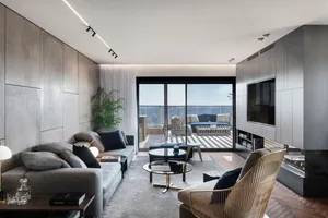 A modern living room featuring glass, metal, and wood elements.