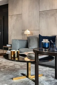 A modern minimalist living room with metallic and matte surfaces.