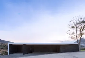 A modern house with a minimalist design, featuring concrete exterior walls.