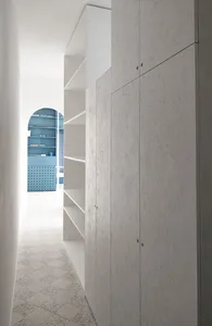 Modern minimalist wardrobe interior with concrete cabinets and shelves.