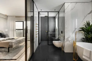 Modern bathroom featuring marble and glass materials, with a sleek, contemporary design.