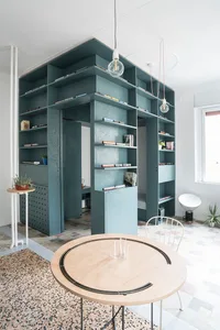 Modern living room with built-in shelving and terrazzo flooring.