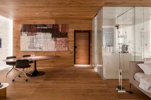A modern office space featuring wooden flooring, contemporary furniture, and stylish decor.