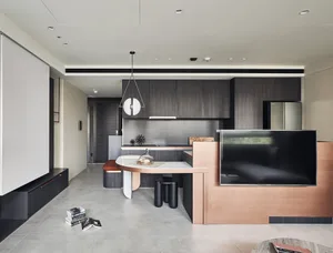 A modern open-plan living and kitchen space with metallic accents