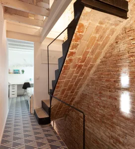 Indoor staircase with brick walls and metal railings in a loft apartment