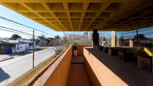 Concrete balcony with a view of a street and neighboring buildings.