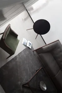 A modern living room featuring a mix of wood, leather, and cotton materials.