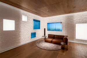 A modern living room with wooden walls and a brown leather sofa.