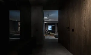 A spacious, modern living room with sleek, dark furnishings and concrete walls.