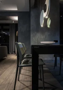 Modern dining room featuring a sleek black table and chairs with a contemporary concrete finish.