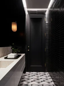 Modern minimalist black bathroom with marble floor and white accents.