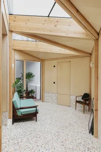 A modern entryway featuring terrazzo flooring and concrete walls.