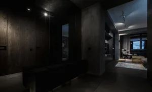 A modern living room with dark concrete walls and minimalist furniture.
