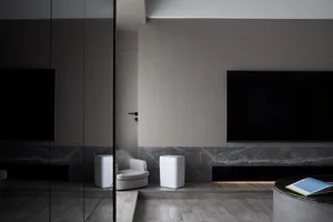 A modern living room featuring a glass wall, concrete floor, and marble accents.