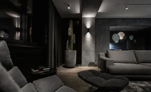 A modern minimalist living room with concrete, wood, and metal accents.