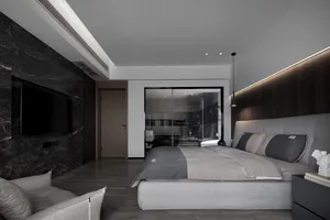 A modern minimalist bedroom with a gray upholstered bed, dark marble accent wall, and dark wooden flooring.
