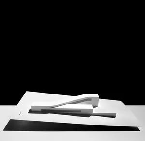 A minimalist architectural model made of white plastic, with clean lines and simple forms.