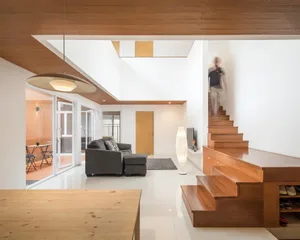 A minimalist residential interior with white and wooden elements.