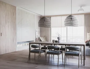 A modern dining room featuring wooden furniture and a large window with a view of the ocean.