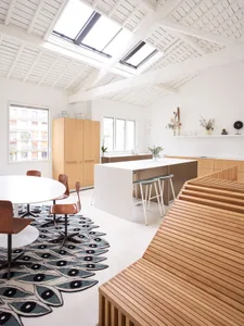 Modern, minimalist residential kitchen featuring white wood cabinets and a central island.