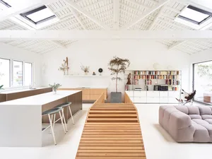 Modern living room with wood flooring, concrete walls, and minimalist design.