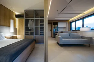 A modern minimalist apartment showcasing a spacious open-concept living area with a kitchen, bedroom, and living room.