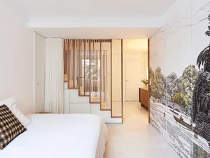 A minimalist bedroom with white decor, showcasing simple and clean design elements.