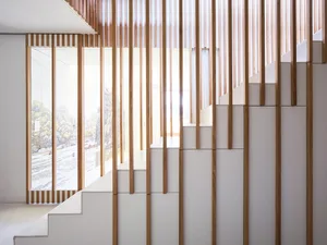 Staircase featuring a modern minimalist design with white panels and wooden accents.
