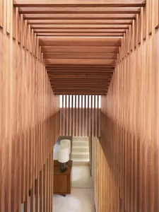 Interior view of a hallway with a wooden staircase and wood-paneled walls.