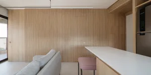 A modern kitchen with wooden panels and a white countertop.