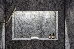 Modern bathroom featuring a marble shelf with a handheld showerhead, soap bar, and fragrance bottles.