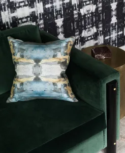 Modern lounge featuring a green velvet couch and a marble accent table.