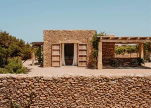A minimalist house with stone exterior and wooden accents.