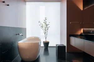 Modern bathroom featuring marble and concrete backsplash, walnut cabinets, and a minimalist freestanding bathtub with a green