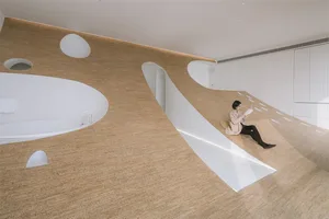 A modern relaxation zone featuring wooden paneling, with a woman reading a book on a bench
