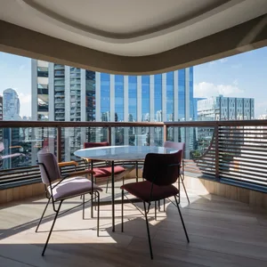 A modern interior design featuring a curved balcony with a view of high-rise buildings.