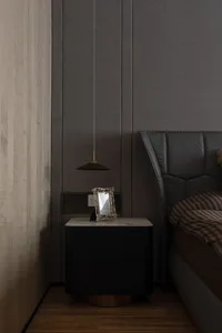 A minimalist bedroom with a wooden floor, a bed, a nightstand, and a pendant light hanging from the ceiling.