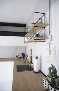 A minimalist kitchen featuring wood countertops, metal shelves, and marble finishes.