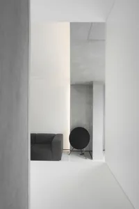 Minimalist interior design featuring concrete walls and a lounge area.