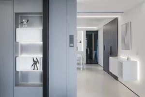 Modern minimalist living room with white walls and furniture, illuminated by subtle, built-in lighting.