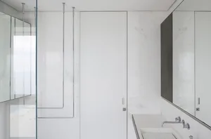 Modern bathroom with white marble walls and floor, minimalist design.