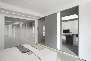 Modern bedroom featuring glass, wood, and leather furniture, showcasing contemporary design elements and sleek finishes.