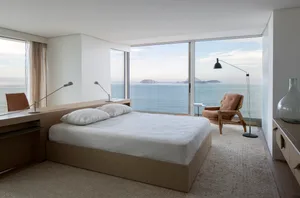 Modern bedroom featuring minimalist design with white and neutral textured furnishings.