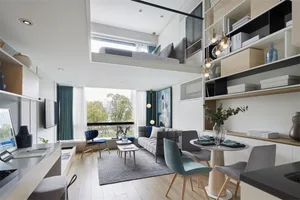 Modern living room featuring a wood floor, minimalist furniture, and a couch with pillows.