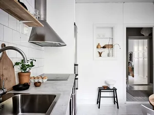 簡約風格廚房，配備混凝土檯面、不鏽鋼家電，以及白色瓷磚 backsplash。
